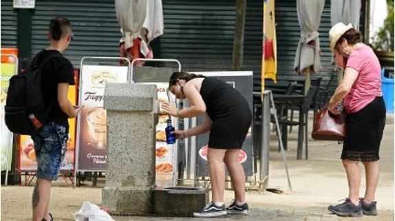 Des personnes remplissent leur bouteille d’eau dans une fontaine publique en Espagne 