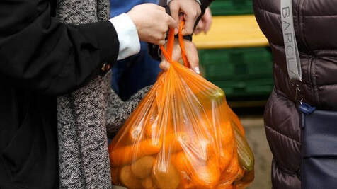 Une personne portant un sac de denrées alimentaires